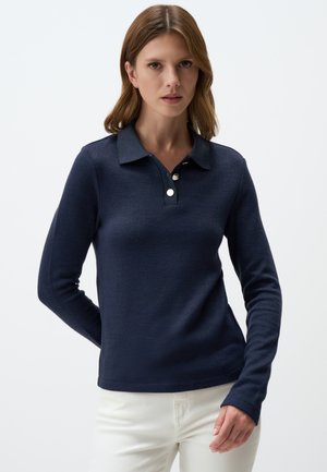 Navy long-sleeve polo shirt made of textured fabric. Features a classic collar, three-button placket, and fitted design. White buttons accent.
