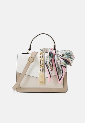 Beigā un baltā strukturēta rokassoma ar teksturētu virsmu, zelta aksesuāriem un ziedu šalli, kas piesieta pie siksnas.