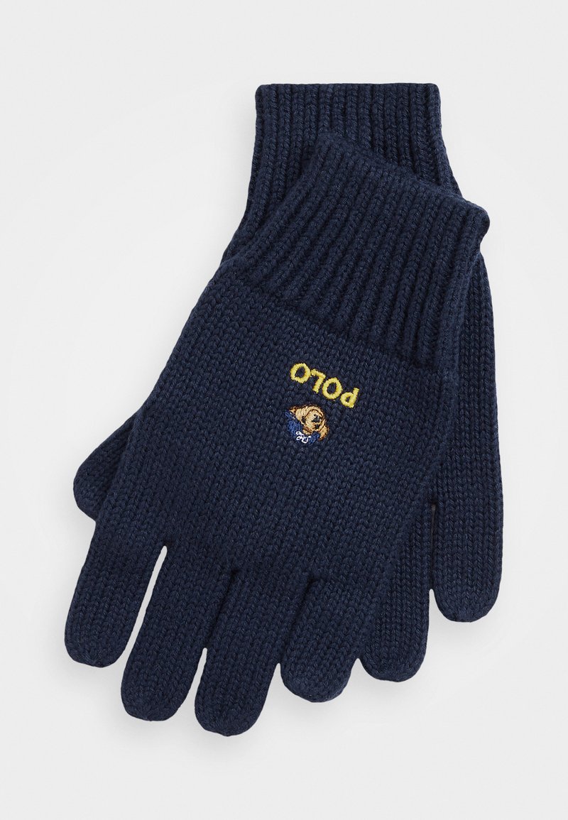 Marina stickade handskar med ribbade mudd, som har gul "polo" broderi och en liten logotyp av en björnfitta i blå skjorta på handflatan.