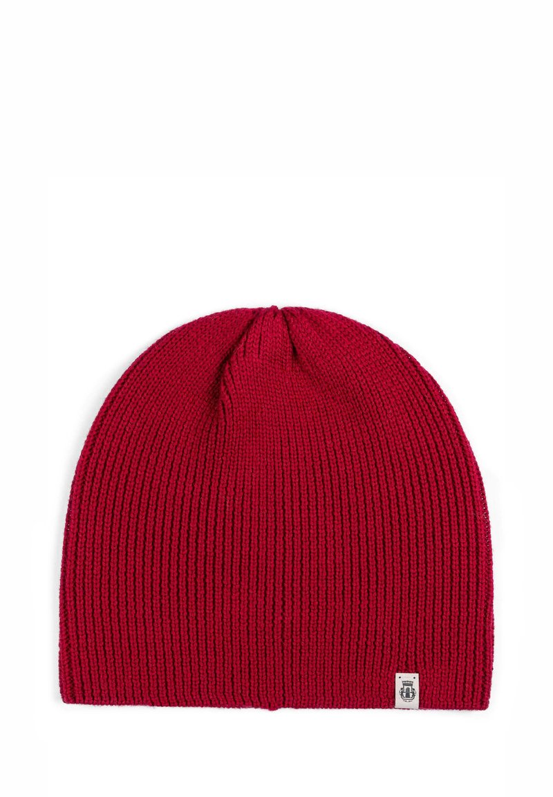 Red knitted beanie hat with a ribbed texture and a small white logo patch at the bottom right. Soft material and rounded top design.