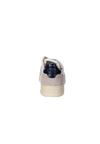 Sneaker bianco con accenti in suede beige, linguetta del tallone in tessuto navy scuro e texture, suola ammortizzata e forma arrotondata. Design semplice con dettagli minimi.