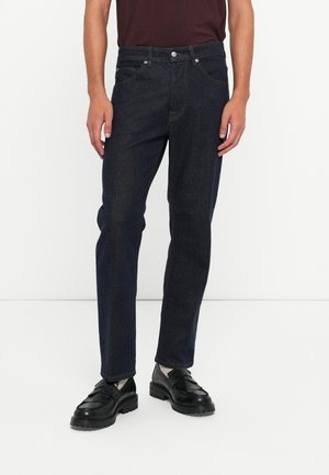 Dunkelblaue Jeans mit geradem Schnitt, fünf Taschen und metallischem Knopfverschluss. Der Stoff hat eine glatte Textur mit subtilen Ausbleichungen.
