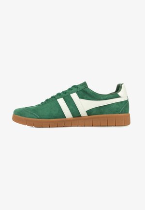Groene suède sneaker met witte designaccenten, voorzien van een gumrubberen zool en een gestructureerd oppervlak. Vetersluiting en een lage profiel.