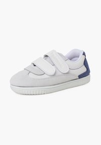 Sneaker bianco con strap in velcro, materiali in suede e pelle, forma rotonda, tomaia testurizzata, dettagli navy sul tallone, suola in gomma.