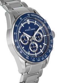 Reloj de acero inoxidable plateado con un dial azul, bisel taquimétrico, tres subdiales y marcadores de hora plateados. Presenta una pulsera de eslabones metálicos.