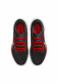 Chaussures de sport noires avec des lacets rouges, empeigne en mesh et détails blancs. Présente une surface texturée et un design de bout rond.