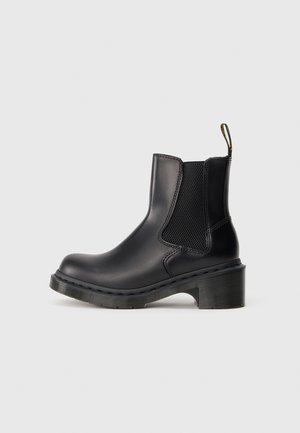 Black leather ankle boot with elastic side panel, loop pull tab, chunky sole, and low block heel, shown in profile against a plain background.