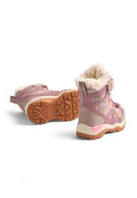 Różowe dziecięce buty z teksturowaną powierzchnią, futrzanym wnętrzem i paskiem na rzep. Podeszwy gumowe z wzorzystym bieżnikiem zapewniającym przyczepność.