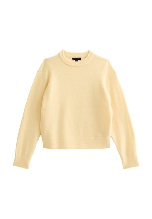 Jersey de manga larga color crema con cuello redondo, puños y dobladillo acanalados, fabricado con una tela de punto suave y texturizada.