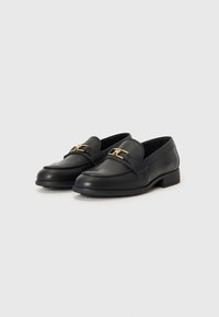 Black leather loafers with a rounded toe, featuring a gold buckle detail and subtle stitching accents, set on a low block heel.