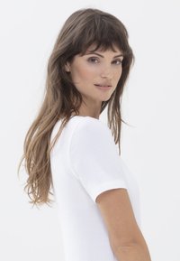 Witte T-shirt met korte mouwen, gemaakt van zachte katoen, met een klassieke ronde halslijn en een aansluitend ontwerp, gefotografeerd tegen een effen achtergrond.
