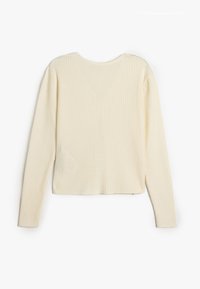 Ribbad stickad tröja i off-white, med långa ärmar och rund halsringning. Mjuk textur med en figurnära silhuett och kort längd.