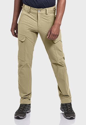 Beige cargo pants with multiple side pockets, a zipper fly, and straight legs. Worn with black hiking shoes, showcasing durable fabric and practical design.