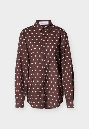 Bruine blouse met knoopjes aan de voorkant en lange mouwen, voorzien van witte stippen, een klassieke kraag en een borstzakje. Glad stoffen textuur.