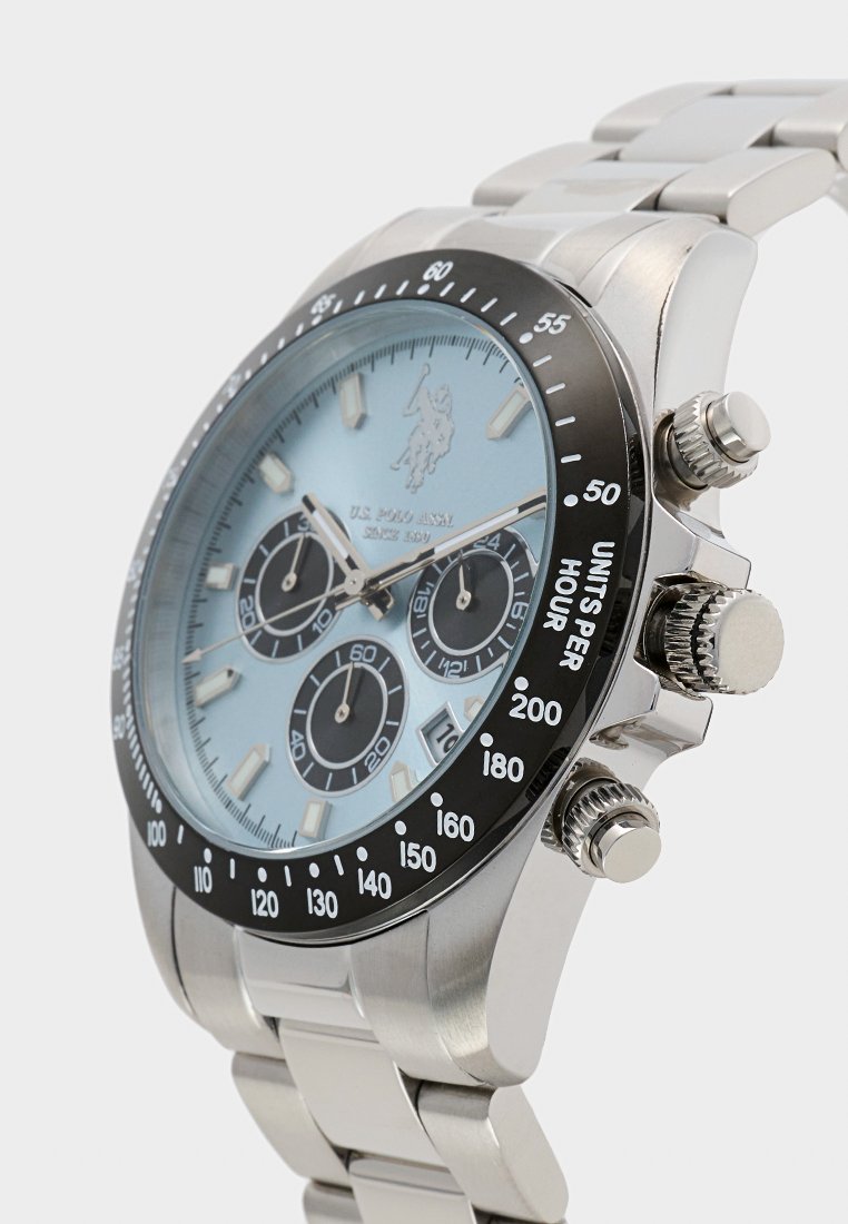 Montre en acier inoxydable argenté avec un cadran bleu clair, une lunette noire, trois sous-cadrans et des fonctions chronographe multifonction.