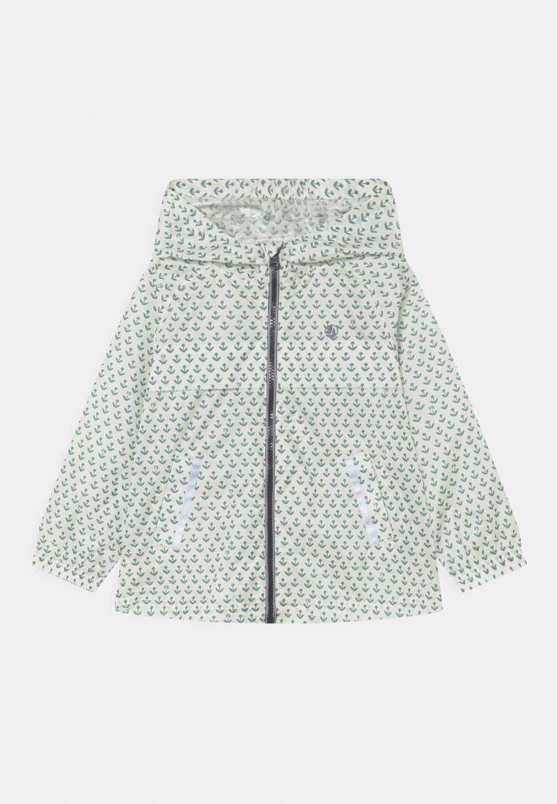 Veste de pluie blanche à capuche avec motif d'ancre verte, fermeture éclair sur le devant et poches latérales.