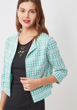 Blazer ligero con estampado en turquesa y blanco, de corte corto y mangas 3/4, combinado con una parte superior negra con detalles de cuentas.