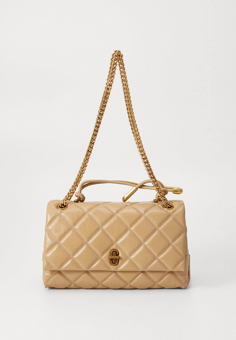 Beige kviltad handväska i läder, med guldkedjesnoddar och en dekorativ spänne fram. Slät yta med diamantmönster.