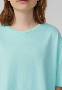 Lichtblauw katoenen T-shirt met een ronde hals en korte mouwen. De stof lijkt glad en heeft een lichte rekbaarheid. Geen zichtbare patronen of accenten.