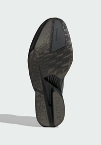 Black athletic shoe sole with textured rubber for traction, featuring a patterned design and branding element, labeled "ADIZERO" on the bottom.