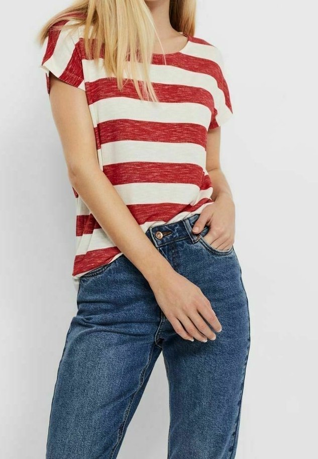 Mujer con una camiseta de rayas horizontales rojas y blancas de manga corta y unos jeans de tiro alto azules, con una mano en el bolsillo, contra un fondo blanco.