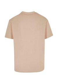 Kortermet t-skjorte, lys beige, bomullsmateriale, rund hals, avslappet passform, sømløse skuldersømmer, ensfarget stoff uten mønstre.