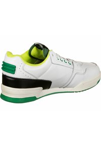 Vita lädersneakers med svarta och gröna detaljer. Har vadderad krage och tunga, snörning fram, och texturerad svart häl.