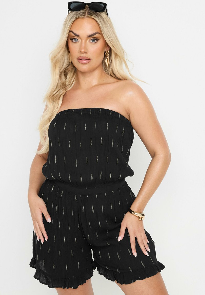 Svart, axelbandslös jumpsuit med texturerad tyg, metallisk guldrandmönster, volangkant och elastisk midja.