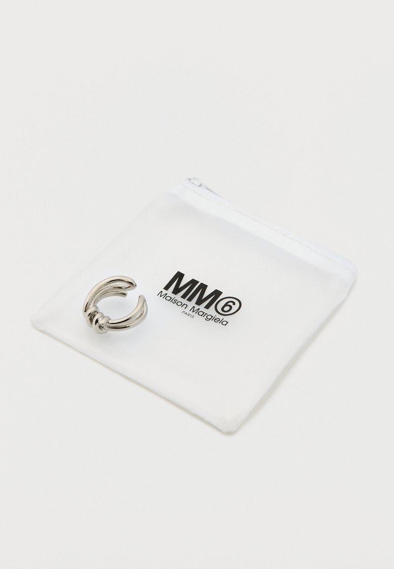 White zippered pouch featuring the MM6 Maison Margiela logo, alongside a metallic silver ring with a twisted design.