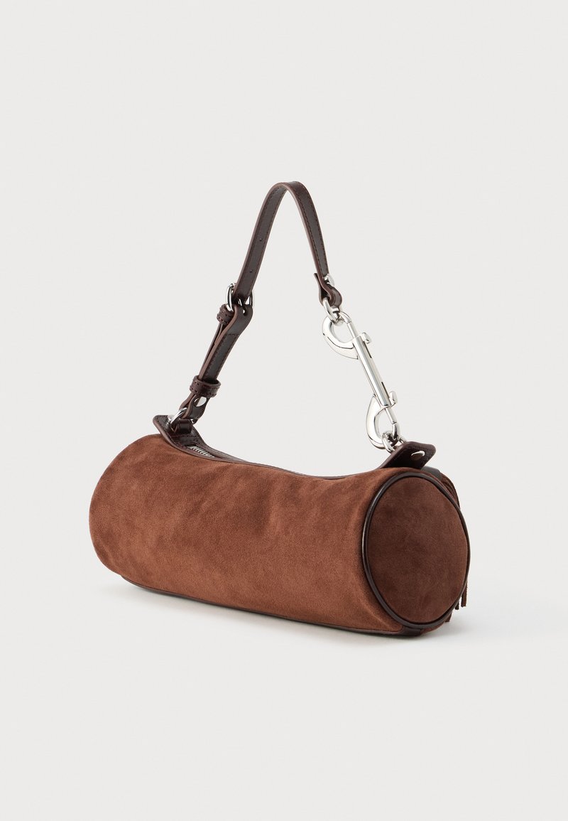 Brown suede cylindrical bag with a brown leather strap, silver hardware, and flat circular ends. Seamless design with textured surface.