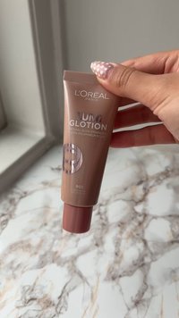 L'Oréal Paris Lumi Glotion Natural Glow Enhancer i en lättviktig tub. Bronsfärg, jämn textur, med silverfärgad text och en vridlucka.