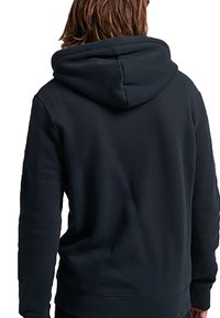 Felpa con cappuccio scuro in tessuto morbido. Presenta una vestibilità comoda, polsini e orlo a costine. Design minimalista senza loghi visibili.