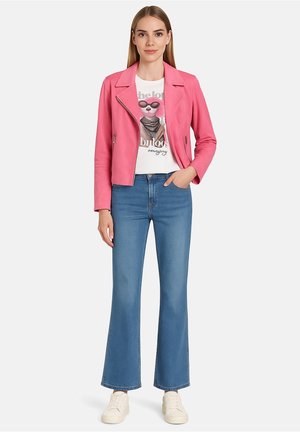 Veste de biker en cuir synthétique rose, t-shirt graphique blanc, jeans évasés bleu clair et baskets blanches. Détails de fermeture éclair et de revers sur la veste.