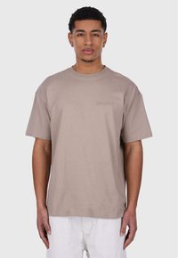 Beige cotton t-shirt with short sleeves and a crew neck. Features a subtle embroidered logo on the chest. Straight cut, soft texture.