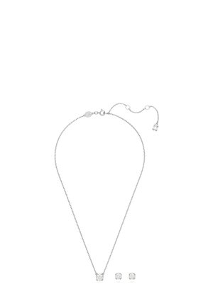 Collar de plata con un colgante central de gema clara; los pendientes de botón a juego presentan gemas claras similares. Todos tienen un acabado pulido.