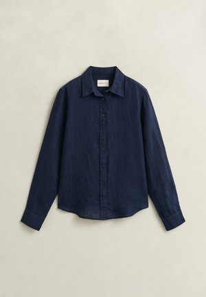 Marineblauw overhemd met lange mouwen, knopen, kraag, manchetten en effen stof, plat gelegd op een lichte achtergrond.