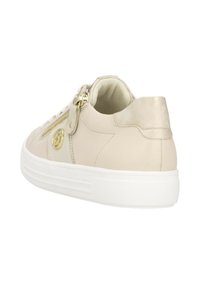 Sneaker beige chiaro con upper in pelle liscia, suola in gomma bianca, accenti in hardware dorato e dettaglio con zip laterale. Il tallone posteriore ha una finitura metallica.