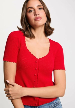 Cardigan corto a maniche corte di colore rosso, con scollatura a onde e chiusura frontale con bottoni, caratterizzato da motivi a rombi testurizzati e accentuazioni a coste.