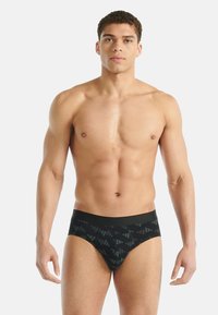 Czarne majtki w wzory wykonane z miękkiej tkaniny, z kontrastującym pasem w geometryczny wzór w odcieniach szarości.