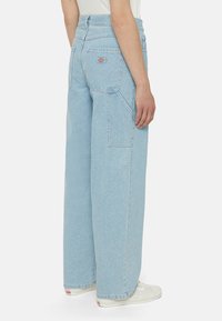 Světle modré denimové kalhoty s širokými nohavicemi a vysokým pasem, se zadními kapsami a s logem značky poblíž pravé kapsy.