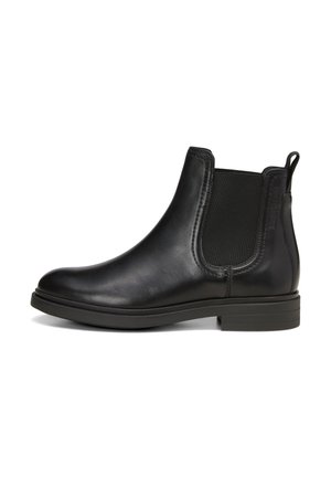 Black leather Chelsea boot with elastic sides, rounded toe, low stacked heel, and textured accents. Flat sole for stability.