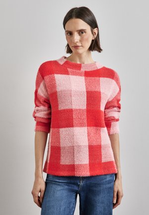 Röd och rosa rutmönstrad tröja med rund halsringning, långa ärmar och mjuk, fluffig textur. Matchad med blå denimjeans.