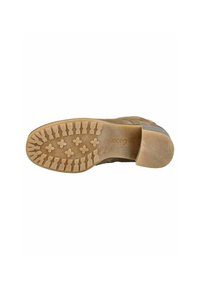 Semelle de chaussure en daim marron avec une semelle extérieure en caoutchouc texturé présentant un motif de crampons pour une adhérence et un léger talon. Nom de la marque "Gabor" en relief.