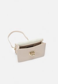 Borsa a mano beige chiaro con superficie testurizzata, accessori in oro, una tracolla corta e chiusura a pattina. Aperta per mostrare un interno foderato morbido.