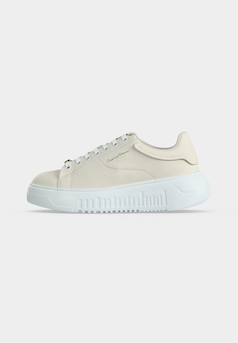 Χαμηλό μπεζ αθλητικό παπούτσι με άσπρη χοντρή σόλα, σχέδιο με κορδόνια μπροστά και διακριτικό λογότυπο στη μία πλευρά, εμφανίζεται από την εξωτερική πλευρά.