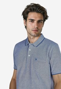 Blaues Polo-Shirt mit kurzen Ärmeln aus strukturiertem Strick, gestreiftem Kragen, drei Knöpfen und einer Brusttasche. Dezente Details im Stoff.