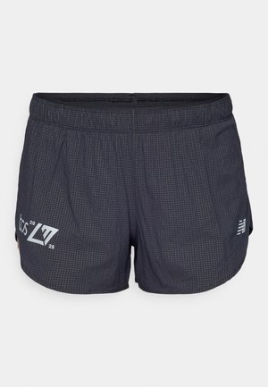 Shorts de sport noirs avec un motif texturé, une taille élastique et des fentes latérales. Logo gris clair sur la jambe gauche.