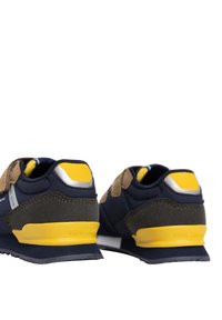 Zapatillas en azul marino y gris con acentos amarillos, materiales de ante y sintéticos, forma redondeada, suelas acolchadas y detalle del logo en el talón.