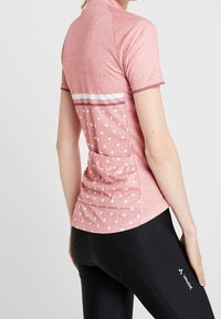 Koszulka kolarska z krótkim rękawem w melanżowym różu z białymi paskami i kropkami, z tylną kieszenią i oddychającego materiału.