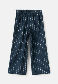 Temno modri široki hlače z majhnim belim cvetličnim vzorcem in elastičnim pasom, razporejene na svetli podlagi.